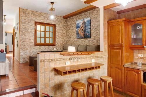 a kitchen with a counter and stools in a room at El Rinconcito del Faro in Gáldar