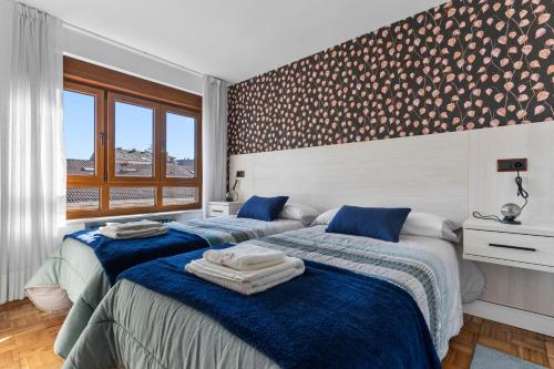 a bedroom with two beds and a window at Comarca del Sella in Arriondas