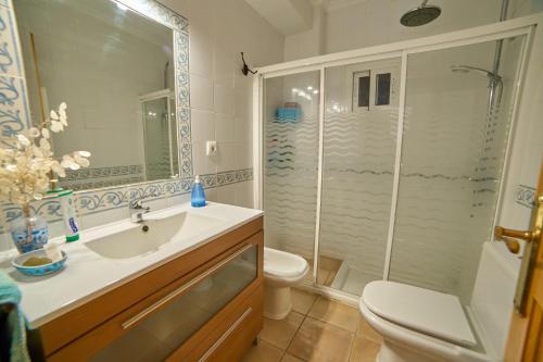a bathroom with a shower and a sink and a toilet at Huerta del Sol in Aracena