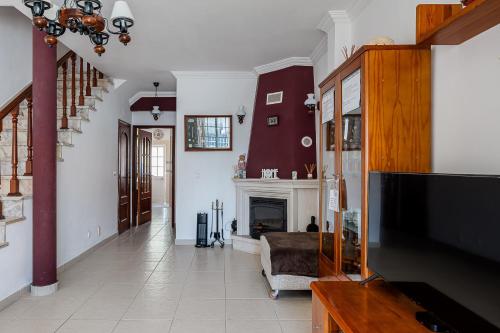 a living room with a tv and a fireplace at Alojamento Local Família Coelho in Quinta do Conde