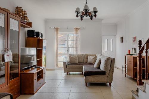 a living room with a couch and a window at Alojamento Local Família Coelho in Quinta do Conde