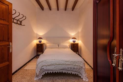 a bedroom with a white bed with two night stands at Villa Ca Sa Padrina in Santanyi