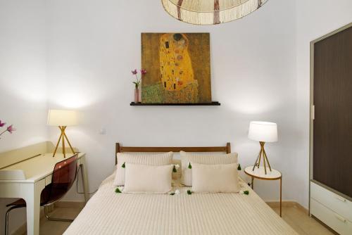 a bedroom with a bed and a desk and a painting at Bungalow Aloe Dunas in Maspalomas