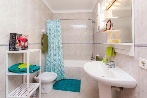 a bathroom with a sink and a toilet and a bath tub at Villa Ca Sa Padrina in Santanyi