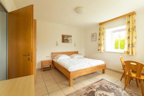 a bedroom with a bed and a table and a window at Appartment Isabelle Terra in Lake Pressegg