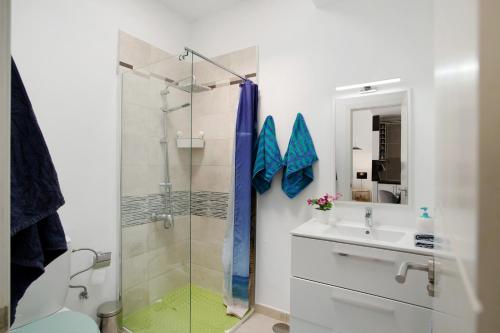 a bathroom with a glass shower and a sink at Bungalow Aloe Dunas in Maspalomas