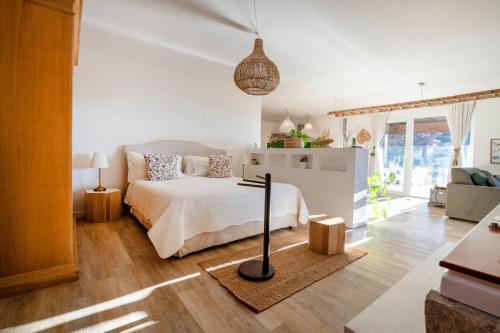 a white bedroom with a bed and a living room at Villa Torto with private pool in Monopoli