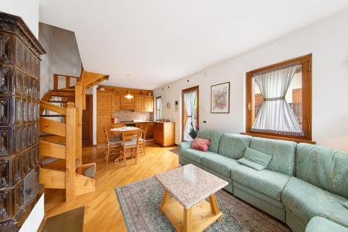 a living room with a blue couch and a kitchen at Appartamento Al Pelmo a Vinigo in Vinigo