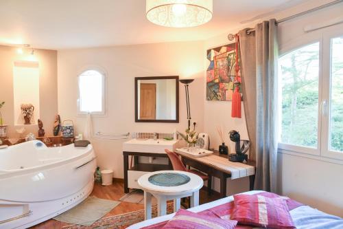 a bathroom with a sink and a toilet and a tub at Maison d'hotes Dolce Vita in Veyssilieu