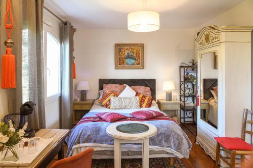 a bedroom with a bed and a table at Maison d'hotes Dolce Vita in Veyssilieu