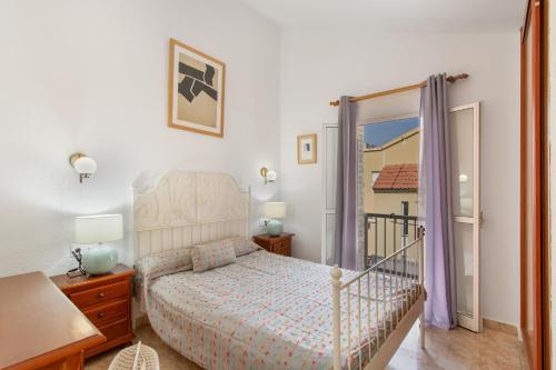 a bedroom with a bed and a door to a balcony at Maspalomas Green Oasis in San Bartolomé