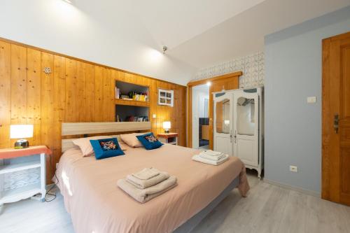 a bedroom with a large bed with towels on it at Le Chalet des Beuquillons in Gérardmer