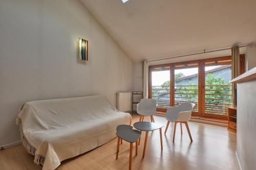a bedroom with a bed and two chairs and a window at Maison Dans Ancienne Forge in Noyarey