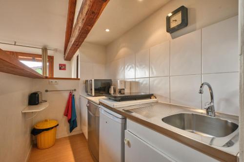 a small kitchen with a sink and a counter at Maison Dans Ancienne Forge in Noyarey