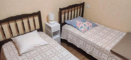 two twin beds in a small room withskirtsomaly at Terre De Pierres - Gite Améthyste in Saint-Geniès
