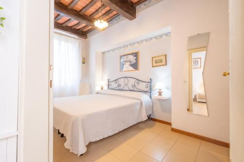 a bedroom with a white bed in a room at Il Nido - Immersi Nell'arte in Lucca