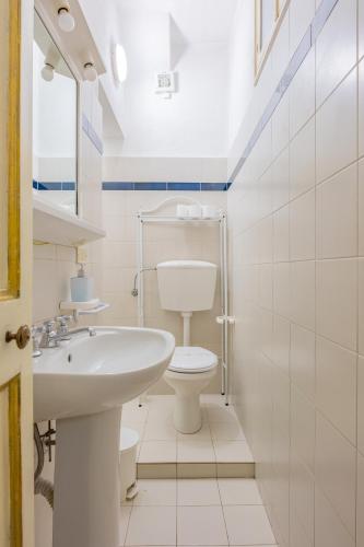 a white bathroom with a toilet and a sink at Il Nido - Immersi Nell'arte in Lucca