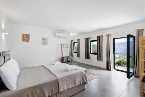 a white bedroom with a large bed and windows at Casa Do Alago in Gove