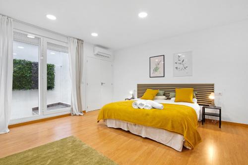 a bedroom with a large bed with a yellow blanket at Ca L'Oliera in Denia