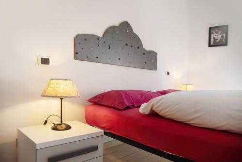 a bedroom with a red bed and a lamp on a table at Mariva in Germignaga