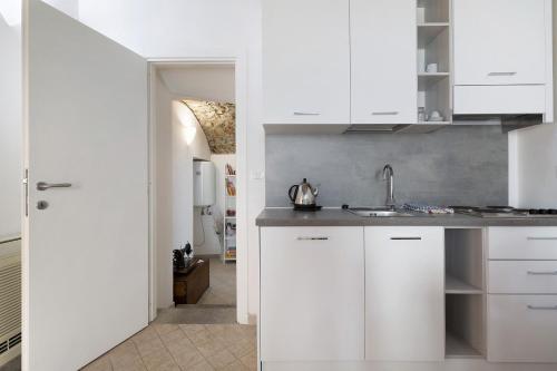 a kitchen with white cabinets and a sink at Ciliegio Agriturismo La Ferla in Toirano