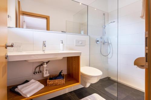 a bathroom with a sink and a toilet and a shower at Niedermaierhof in Kastelbell-Tschars
