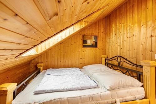 a bed in a room with a wooden ceiling at Blockhaus Marie in Frielendorf