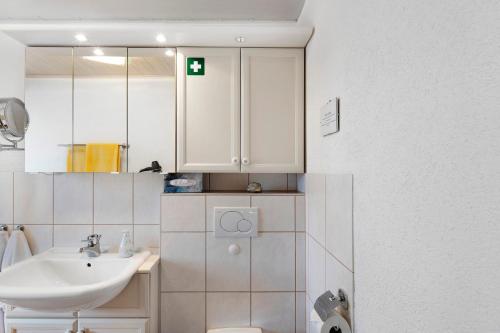 a white bathroom with a sink and a mirror at Ferienappartment Becker Zentrum in Lauterbach