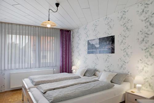 a white bedroom with two beds in it at Ferienappartment Becker Zentrum in Lauterbach