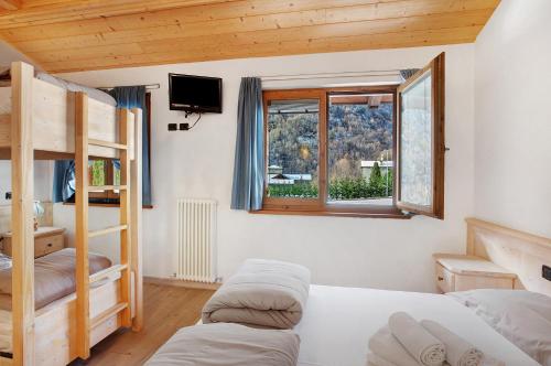a bedroom with two bunk beds and a window at Agriturismo Quinto Quarto in Grosio