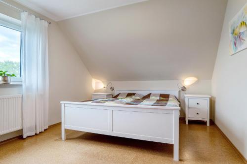 a white bedroom with a white bed and a window at Ferienwohnung in Spelle in Spelle