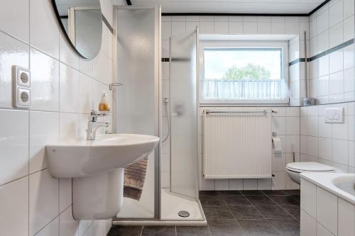 a white bathroom with a sink and a shower at Ferienwohnung in Spelle in Spelle