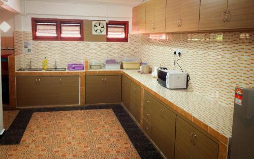 a kitchen with a counter top with a microwave at Nur Muslim Homestay At Kota Bharu in Kota Bharu