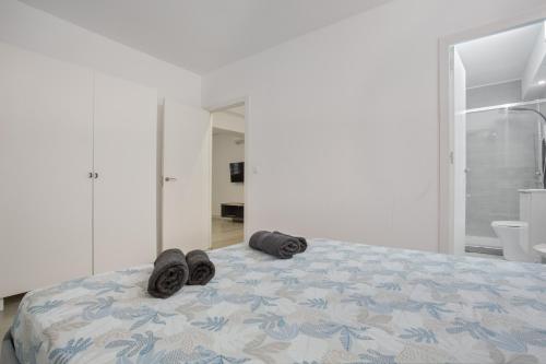 a bedroom with a bed with slippers on it at Las Américas Seafront - Free Wi-fi in Playa de las Americas