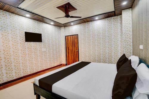 a bedroom with a bed with a ceiling fan at Hotel O NICE HOTEL in Faridabad