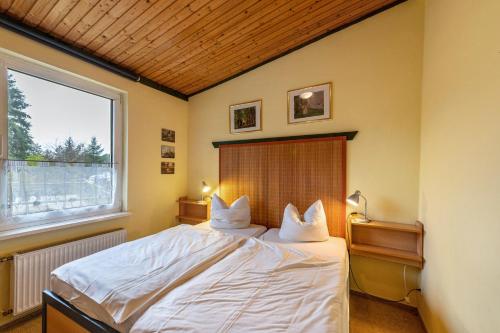 a bedroom with a large bed with two pillows at Krüseliner Mühle - Bungalows in Krüselin