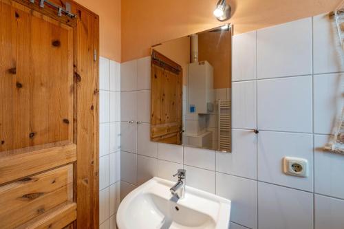 a bathroom with a sink and a mirror at Krüseliner Mühle - Bungalows in Krüselin