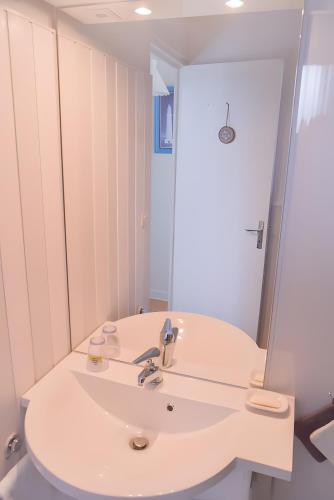 a bathroom with a white sink and a mirror at Gîte De La Voûte in Fécamp