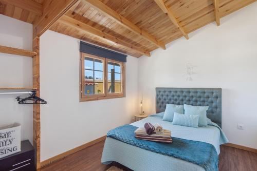 a bedroom with a bed with a blue headboard at Casinha Saragoça e Vergueiro in Ponte de Vagos