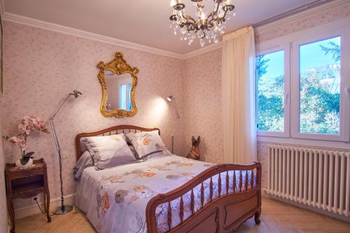a bedroom with a bed and a mirror and a lamp at Au printemps Japonais in Pierre-Châtel