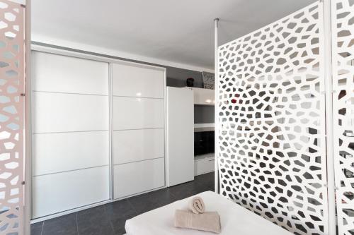 a room with white cabinets and a white bench at Estudio Yumbo Playa Del Ingles in San Bartolomé