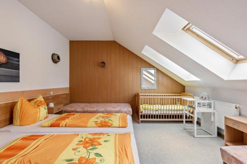 a attic bedroom with two beds and a crib at Ferienwohnung Ufert in Meißen