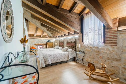 a bedroom with a bed in a room with wooden ceilings at El Rincón de Hornuez in Moral