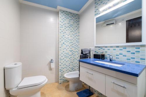 a bathroom with a white toilet and a sink at Apartamento Brétema in Meaño