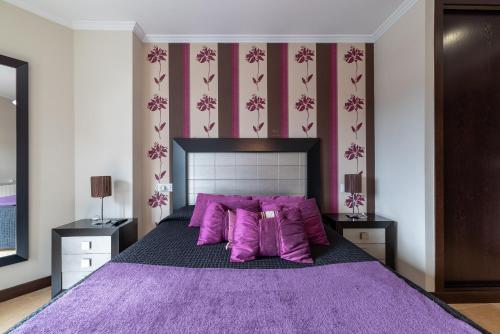 a bedroom with a large purple bed with purple pillows at Apartamento Brétema in Meaño
