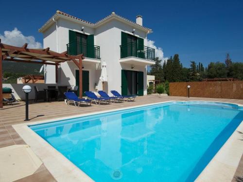 a swimming pool in front of a villa at Sami Beach Villas Nefeli in Karavomylos