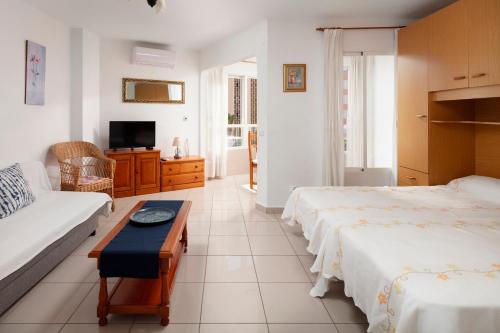 a hotel room with two beds and a couch at Estudio Bloque 84 in Torrox