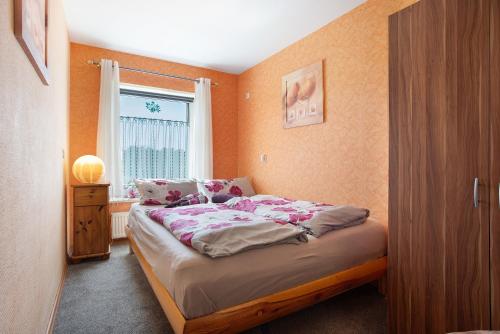 a small bedroom with a bed with a window at Ferienwohnung Lüssow in Lüssow