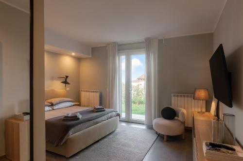 a bedroom with a bed and a window and a chair at Blueyes House Tuscany in Artimino