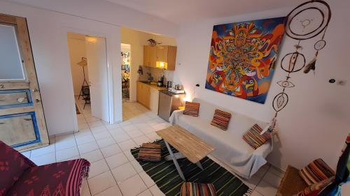 a living room with a table and a kitchen at Syros Mandala Studio in Ano Syros